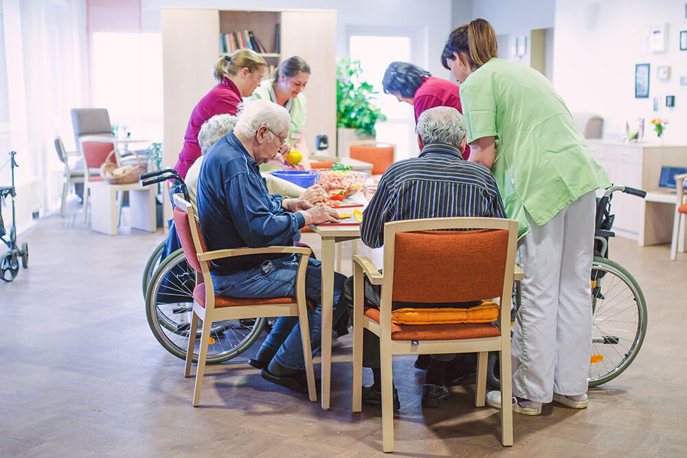 Pfleger bereiten mit Senioren Essen zu