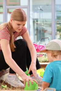 Auch im Sandkasten packt die 16-Jährige mit an und hilft fleißig beim Backen der Sandkuchen (Foto: Friederike Stecklum).