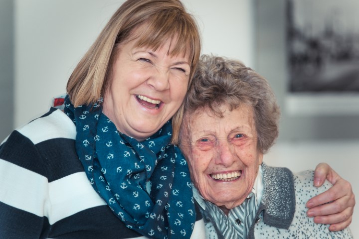 Lachende Seniorin und Mitarbeiterin im Betreuten Wohnen
