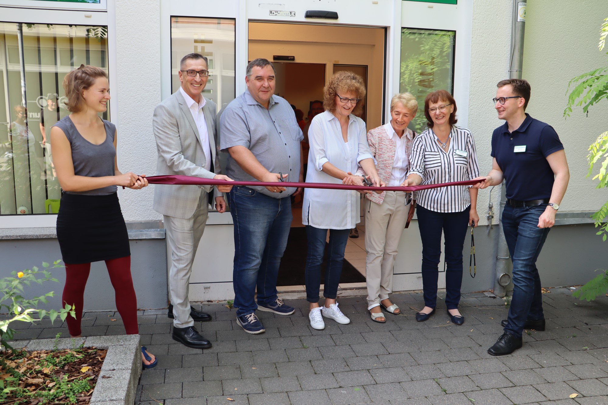 Gemeinsam eröffnen Stefan Adams (Stadt Leipzig), Gothild Lieber (Seniorenbeirat), VS-Geschäftsführerin Christine Manz und Vizevorsitzender Thomas Demmer das Eröffnungsband für den neuen Seniorentreff Sonnenwall.