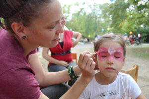 Nicole Schreiber (päd. Fachkraft) verwandelt Mayar in einen kleinen Schmetterling. (Foto: Ulrike Gierth)