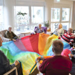 Bewegung in der Gruppe: Gemeinsam koordinieren die Tagesgäste das große bunte Tuch (Foto: Friederike Stecklum).